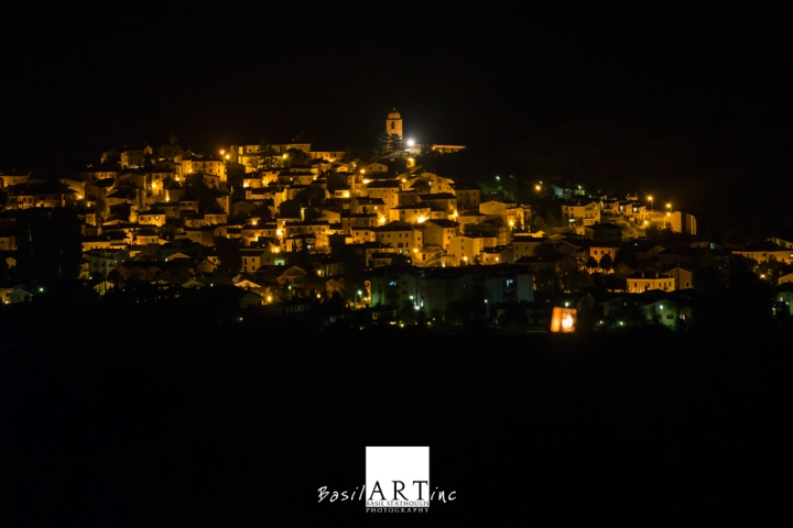 View of Rocca di Mezzo by night withe Punto do Riferimento next to the bell tower
